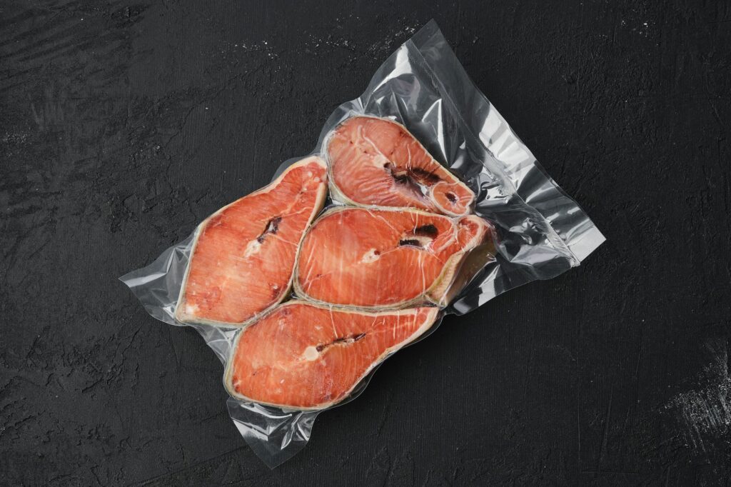 Overhead view of raw salmon steak in vacuum packaging